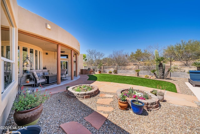 view of yard featuring outdoor lounge area, ceiling fan, a patio area, and a fenced backyard