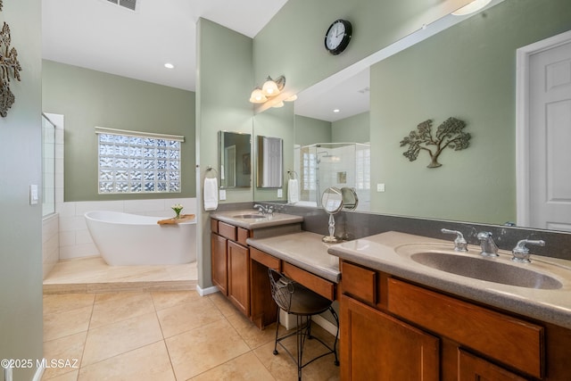bathroom featuring a stall shower, a sink, tile patterned flooring, and a freestanding bath