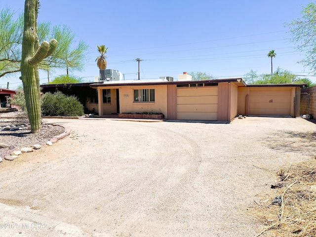 3926 E Camino De Palmas, Tucson, AZ 85711 - view of front of home featuring a garage and dirt driveway