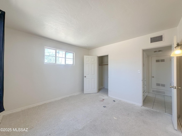 3926 E Camino De Palmas, Tucson, AZ 85711 - unfurnished bedroom featuring light carpet, a closet, a textured ceiling, and baseboards