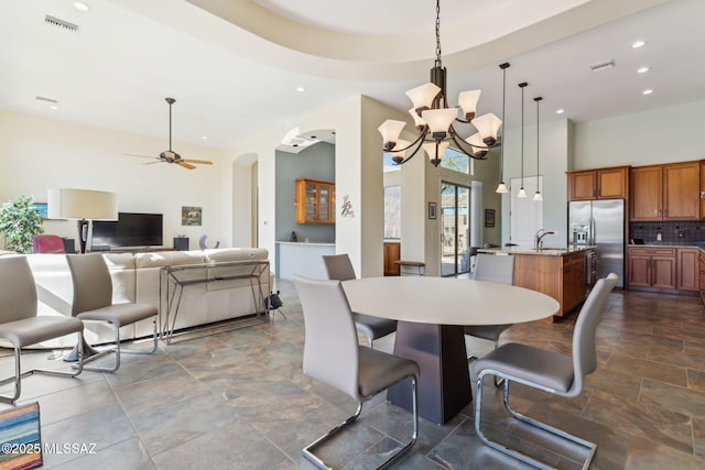 dining room featuring ceiling fan with notable chandelier, visible vents, arched walkways, and recessed lighting