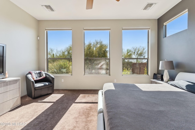 carpeted bedroom with a ceiling fan and visible vents