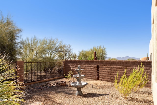 view of yard featuring a mountain view and fence