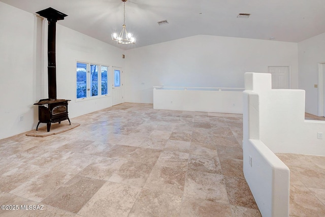 15690 N Roadrunner Ridge Ln, Tucson, AZ 85739 - empty room featuring visible vents, a wood stove, a notable chandelier, and lofted ceiling