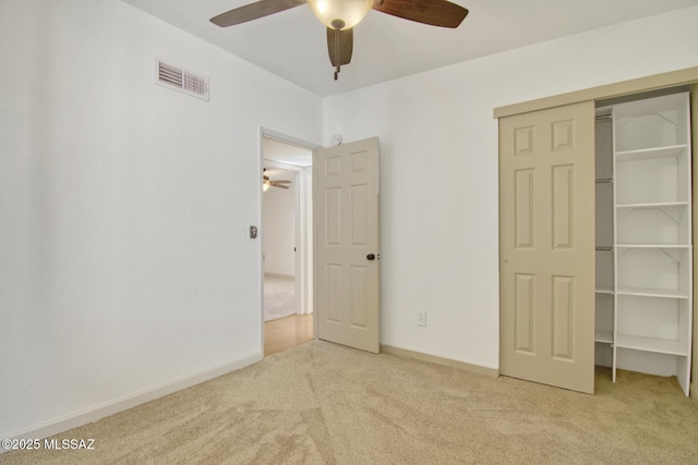 unfurnished bedroom with carpet flooring, visible vents, baseboards, a ceiling fan, and a closet