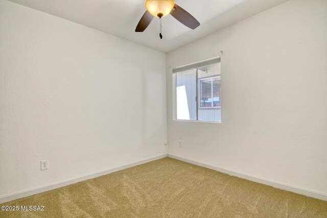 empty room featuring baseboards, light colored carpet, and ceiling fan