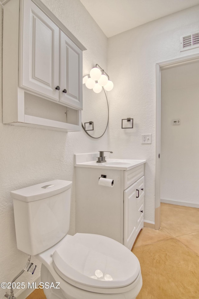 half bath with toilet, baseboards, visible vents, a textured wall, and vanity
