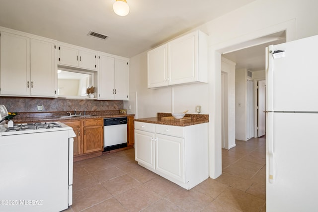 kitchen featuring white cabinets, visible vents, white appliances, tasteful backsplash, and a sink