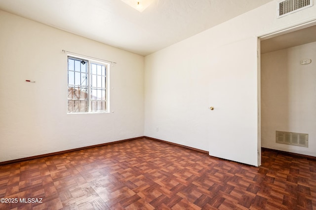 unfurnished room featuring baseboards and visible vents