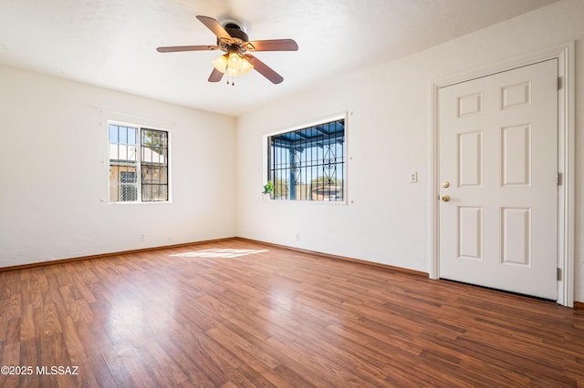 empty room with a ceiling fan, baseboards, and wood finished floors