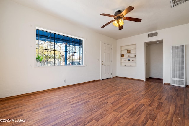 spare room with visible vents, wood finished floors, and built in shelves