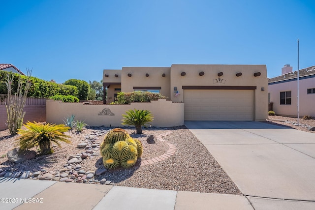 3437 S Abrego Dr, Green Valley, AZ 85614 - pueblo revival-style home featuring stucco siding, an attached garage, a fenced front yard, and concrete driveway