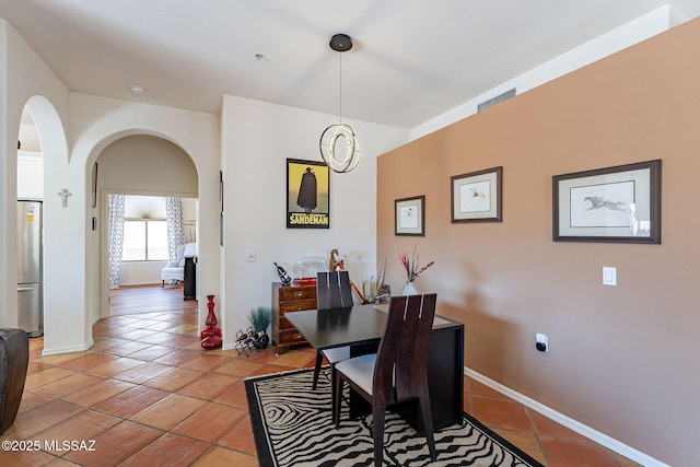 3437 S Abrego Dr, Green Valley, AZ 85614 - dining space featuring light tile patterned flooring, arched walkways, and baseboards