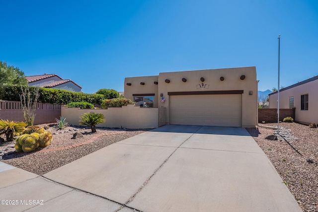 3437 S Abrego Dr, Green Valley, AZ 85614 - pueblo-style house featuring stucco siding, a garage, a fenced front yard, and concrete driveway