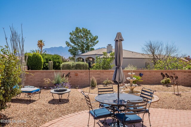 3437 S Abrego Dr, Green Valley, AZ 85614 - view of patio featuring fence, an outdoor fire pit, and a mountain view
