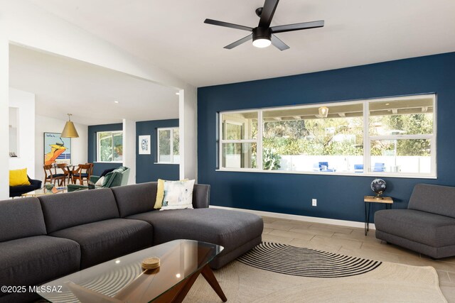living room featuring a ceiling fan and baseboards