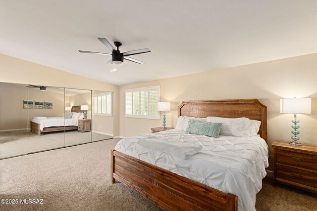 bedroom featuring carpet flooring, a closet, baseboards, vaulted ceiling, and a ceiling fan