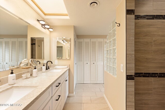 full bathroom featuring tile patterned floors, a sink, baseboards, and a closet