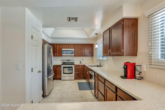 kitchen featuring visible vents, appliances with stainless steel finishes, tasteful backsplash, a sink, and a raised ceiling