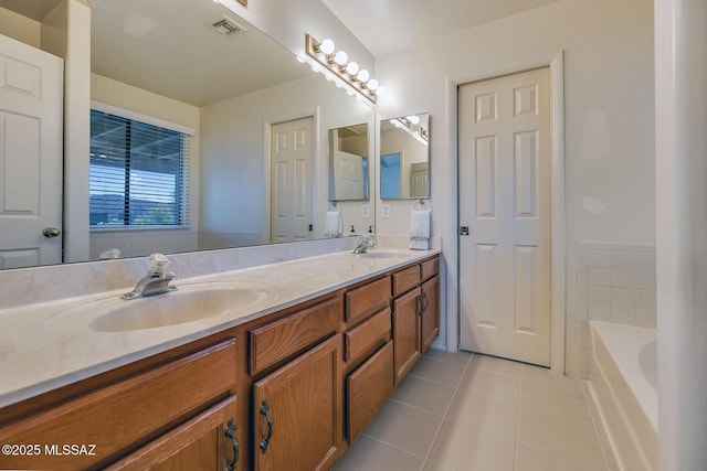 full bathroom with visible vents, double vanity, a bathtub, tile patterned floors, and a sink