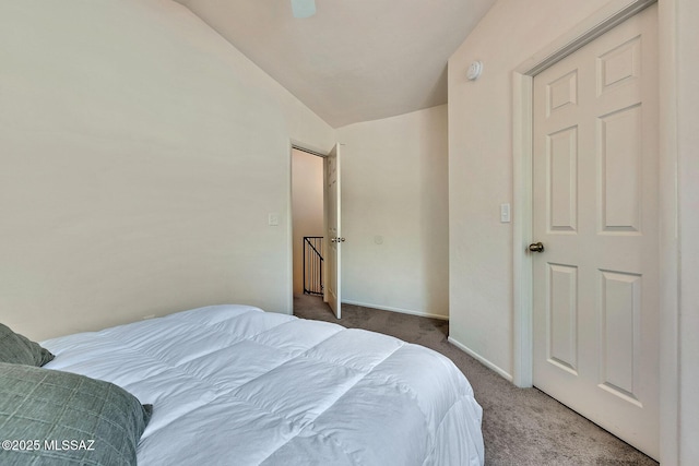 carpeted bedroom with baseboards and vaulted ceiling