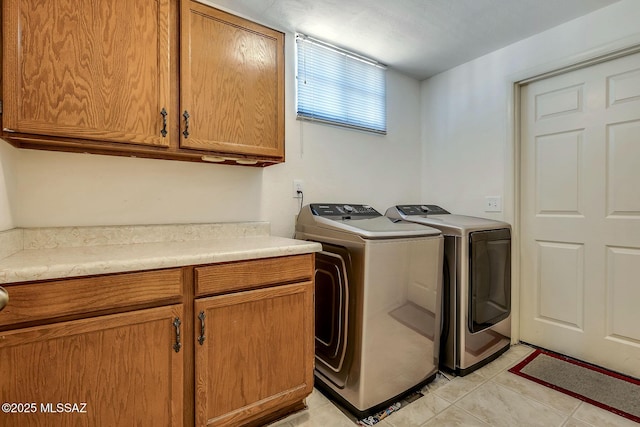 laundry room featuring cabinet space, independent washer and dryer, and light tile patterned floors