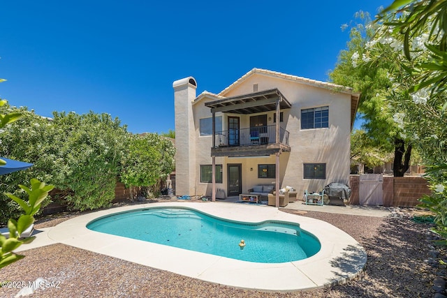 back of property featuring outdoor lounge area, a balcony, a fenced backyard, stucco siding, and a patio area