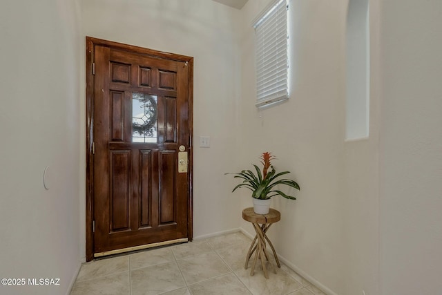 foyer with baseboards and light tile patterned flooring