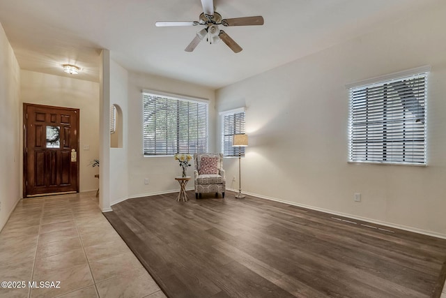 foyer entrance featuring ceiling fan, baseboards, and wood finished floors