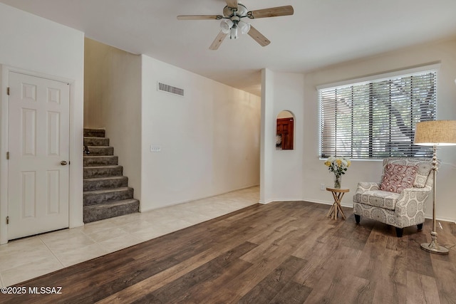 sitting room featuring visible vents, a ceiling fan, wood finished floors, and stairway