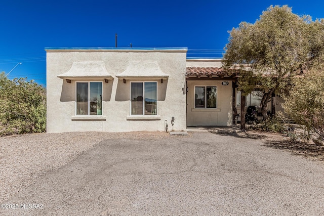 view of front of house featuring stucco siding and a tiled roof