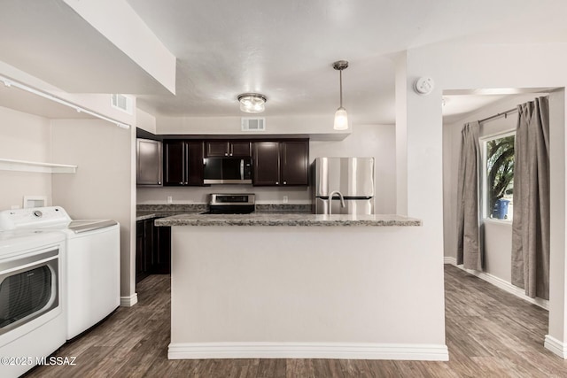kitchen featuring dark brown cabinetry, visible vents, washing machine and clothes dryer, wood finished floors, and stainless steel appliances