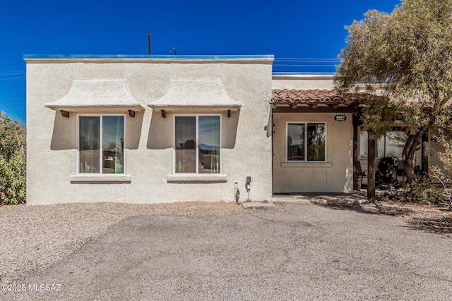 view of front facade featuring stucco siding and a tiled roof