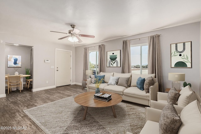 living room featuring baseboards, wood finished floors, and a wealth of natural light