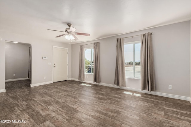 8851 E Elvenstone Way, Tucson, AZ 85730 - spare room featuring healthy amount of natural light, ceiling fan, dark wood-style flooring, and baseboards