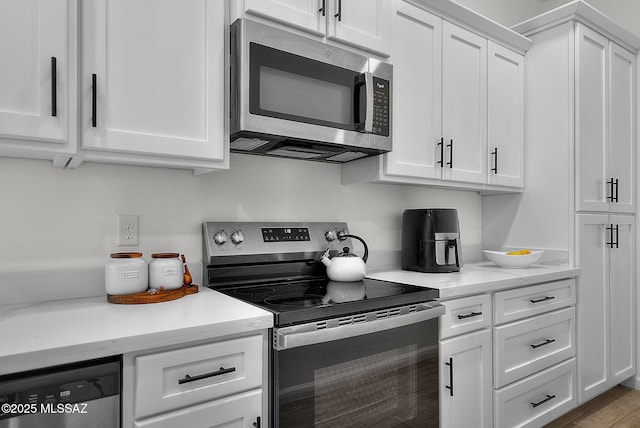 kitchen featuring white cabinets, light stone counters, and stainless steel appliances
