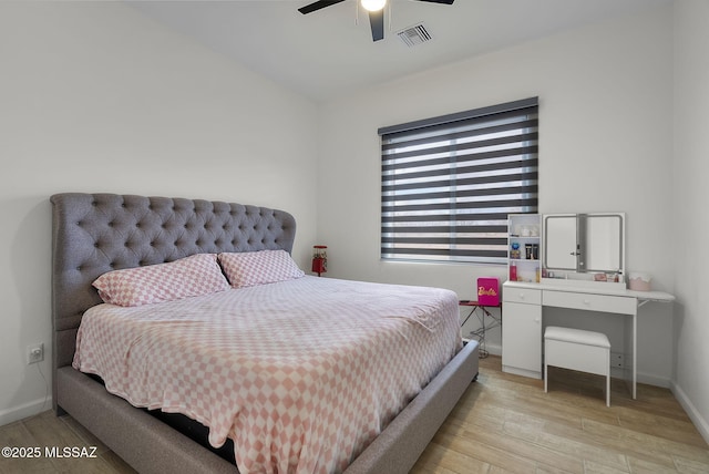 bedroom featuring light wood-type flooring, baseboards, ceiling fan, and visible vents
