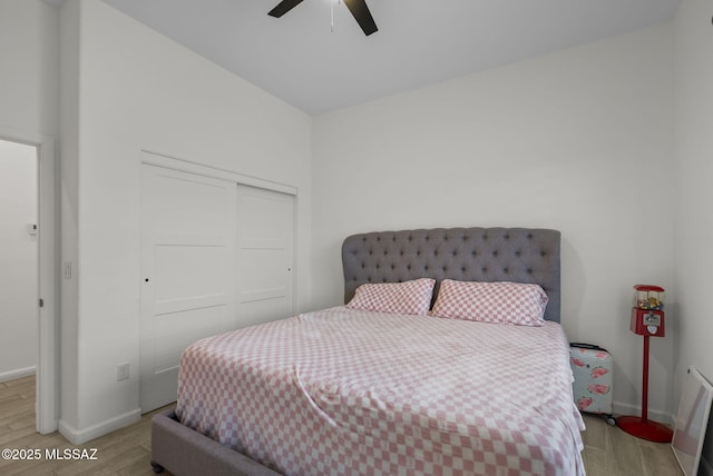 bedroom featuring baseboards, a closet, ceiling fan, and light wood-type flooring