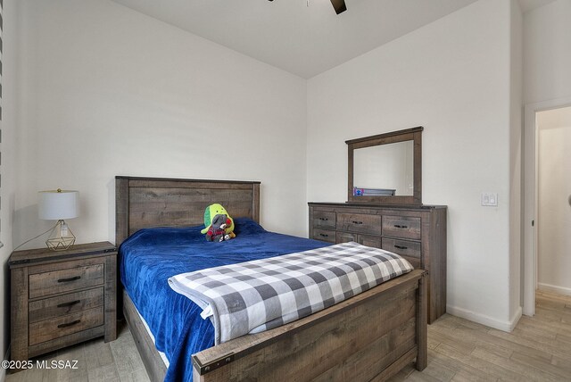 bedroom featuring baseboards, light wood-style floors, and ceiling fan