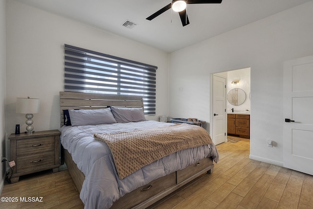 bedroom featuring ensuite bathroom, visible vents, baseboards, ceiling fan, and light wood-type flooring