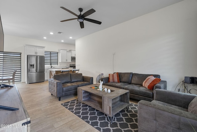 living room featuring a ceiling fan, recessed lighting, light wood finished floors, and visible vents