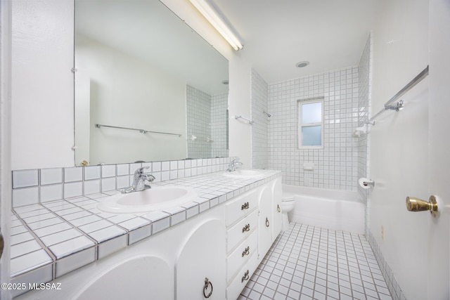 bathroom with double vanity, tub / shower combination, tile patterned flooring, and a sink