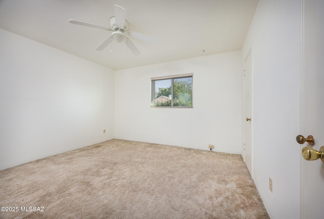 carpeted spare room with a ceiling fan