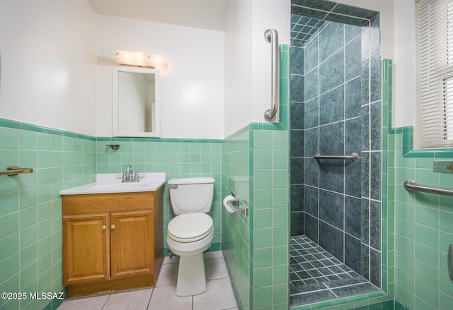 full bathroom with tile walls, a tile shower, toilet, tile patterned floors, and wainscoting