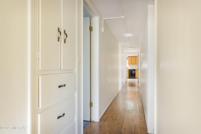 hall featuring baseboards and wood finished floors