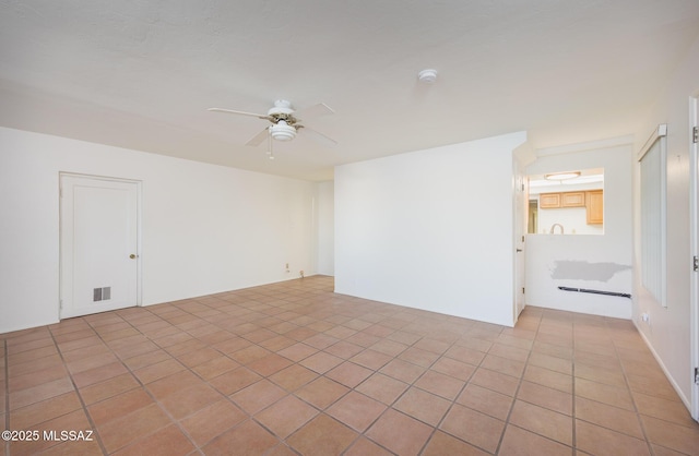 empty room with a ceiling fan, light tile patterned floors, and visible vents