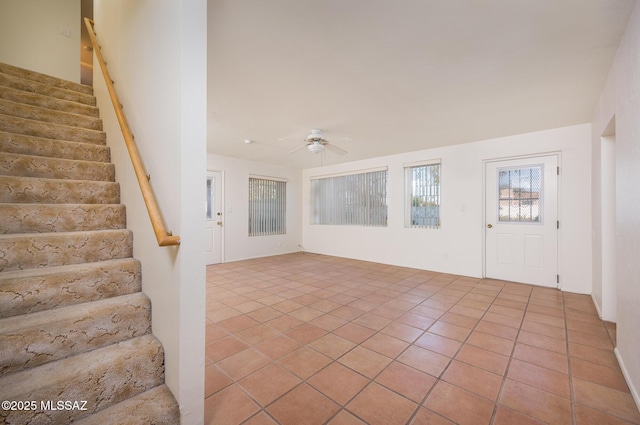 foyer featuring light tile patterned flooring, stairway, and a ceiling fan