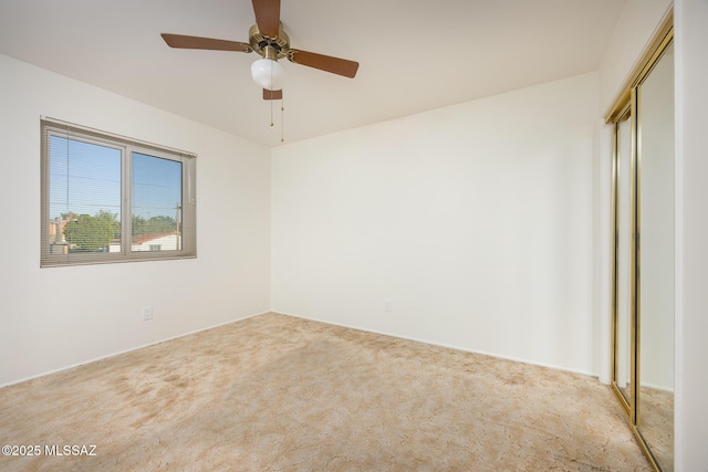 empty room with a ceiling fan and carpet