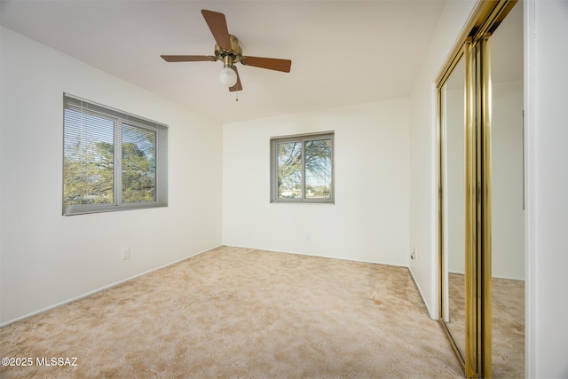 unfurnished bedroom with carpet, a closet, and ceiling fan