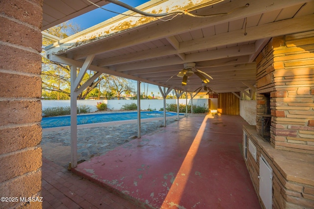 view of patio featuring a water view, ceiling fan, and a fenced in pool